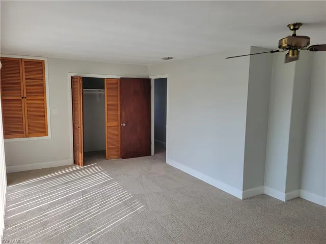 Unfurnished bedroom featuring light colored carpet and a closet