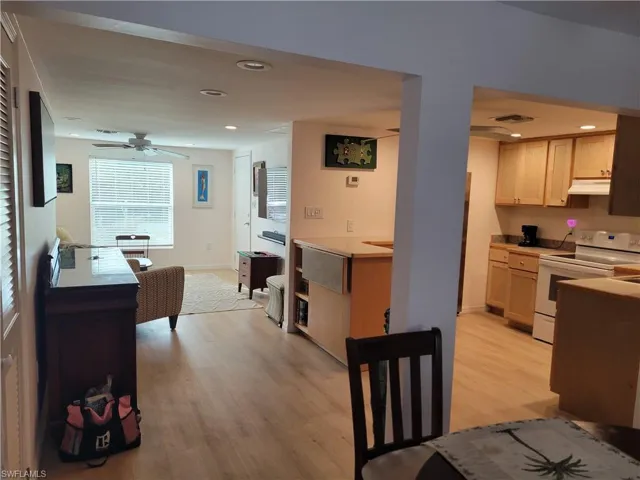 Kitchen with white range with electric stovetop, recessed lighting, light wood-style flooring, light countertops, and a ceiling fan
