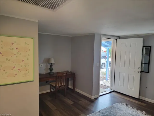 Entryway featuring dark wood-style flooring and ornamental molding