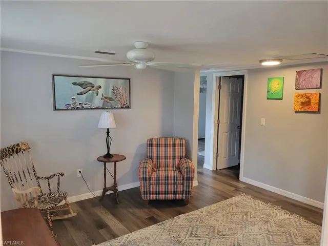 Living area featuring dark wood finished floors and ceiling fan