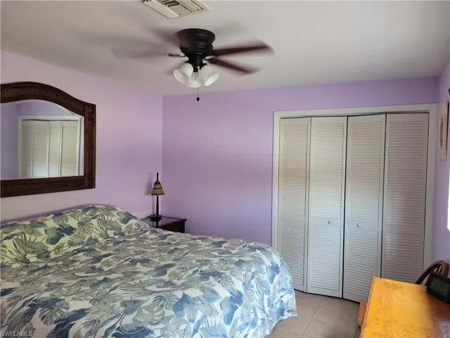 Bedroom featuring light tile patterned floors, a closet, and a ceiling fan
