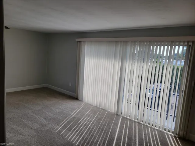 Empty room featuring carpet and baseboards