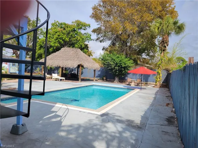 View of swimming pool with patio surround and a fenced backyard