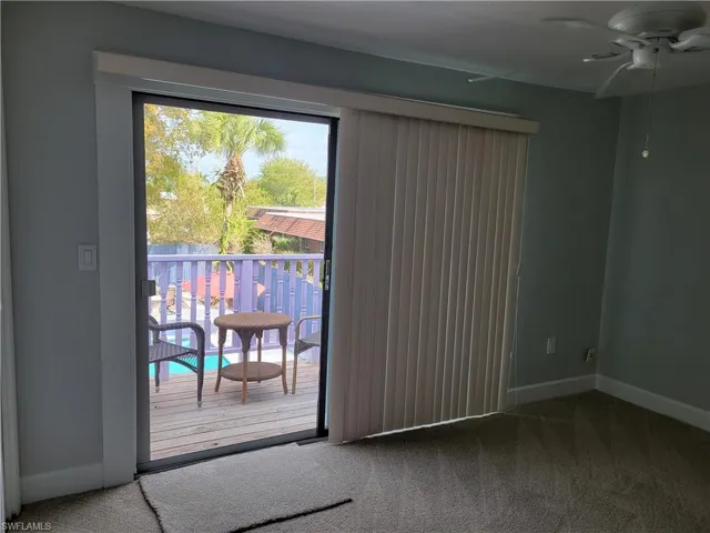 Doorway to outside featuring carpet floors and ceiling fan