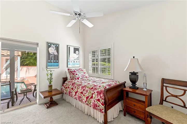 Bedroom featuring carpet floors, a ceiling fan, access to exterior, and a high ceiling