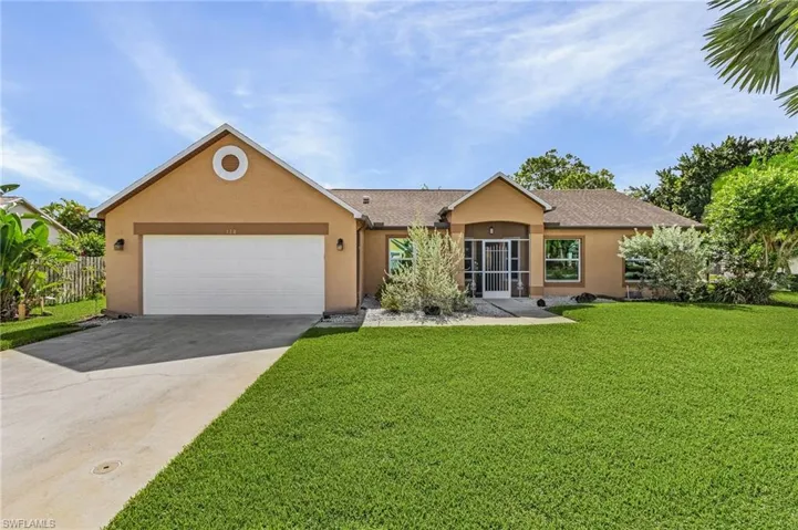 Ranch-style home with a garage and a front lawn