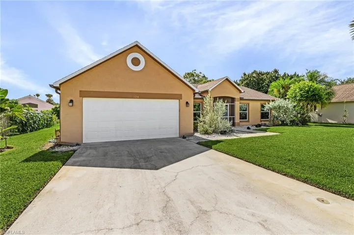 Ranch-style house featuring a garage and a front lawn