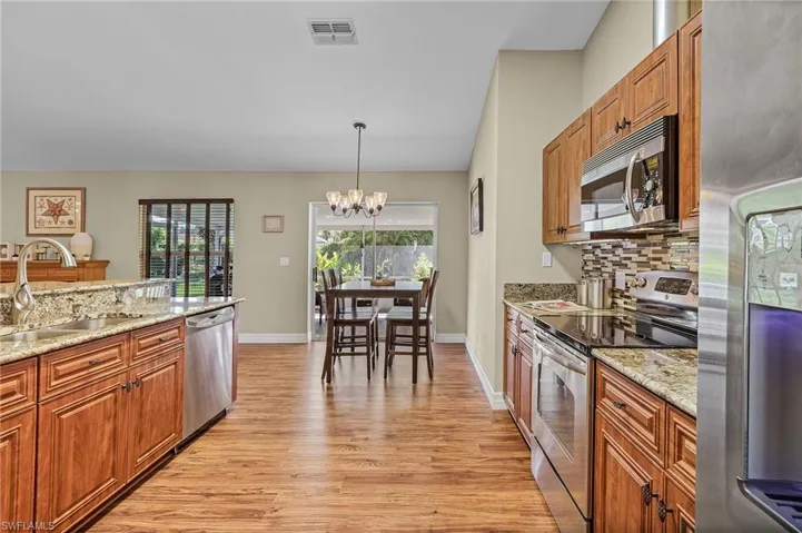 Kitchen featuring light stone counters, light hardwood / wood-style flooring, stainless steel appliances, and sink