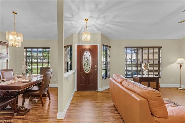 Foyer with light hardwood / wood-style flooring, an inviting chandelier, and a wealth of natural light