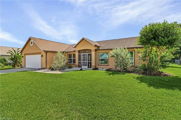 Ranch-style house with a garage and a front lawn