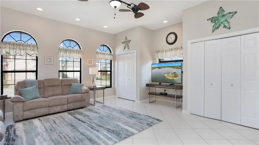 Living room with ceiling fan and light tile patterned floors