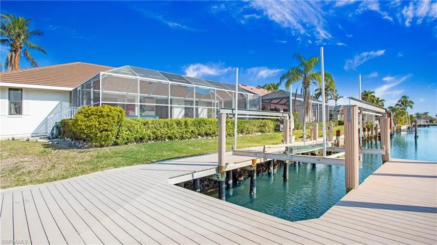 Dock area featuring a lanai, a yard, and a water view