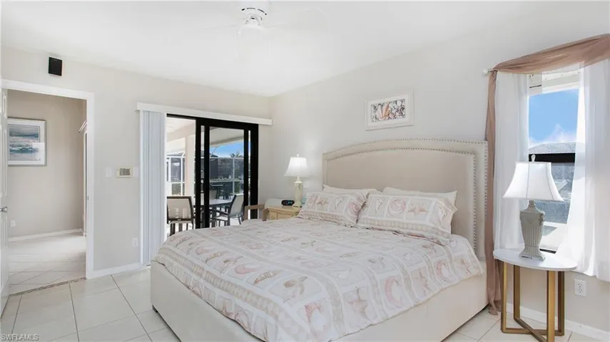 Bedroom with access to exterior, light tile patterned floors, and ceiling fan