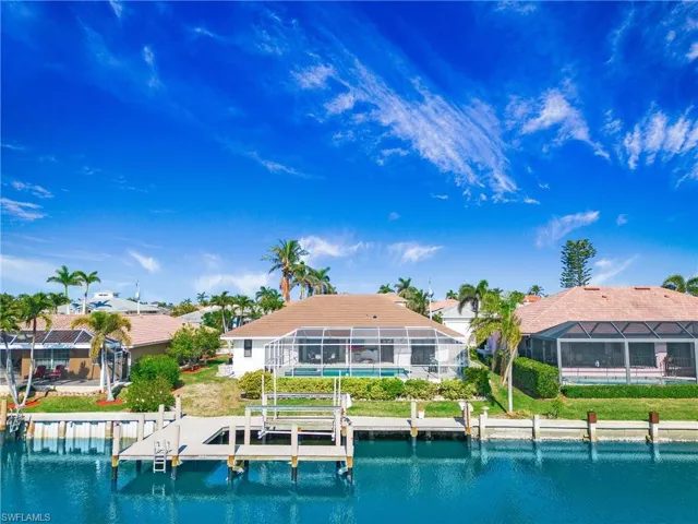 Rear view of house with a lanai and a water view
