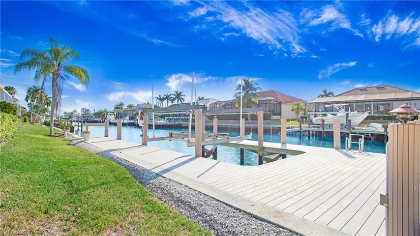 View of dock with a yard and a water view