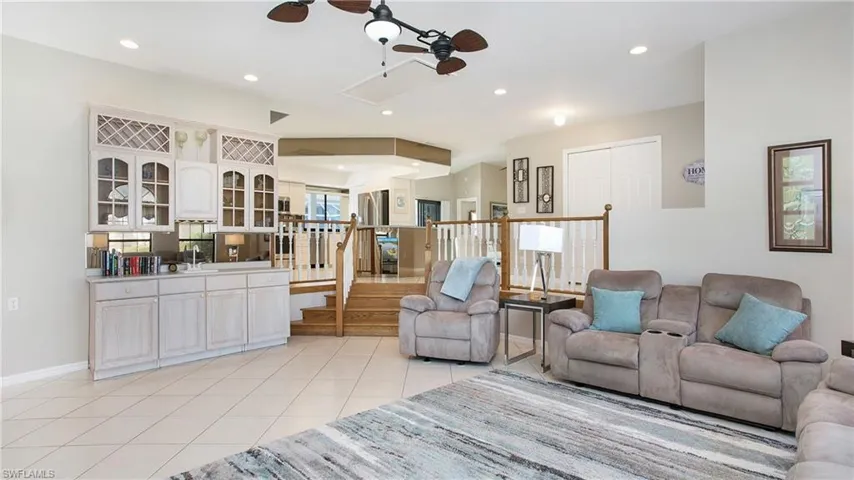 Living room featuring light tile patterned floors and ceiling fan