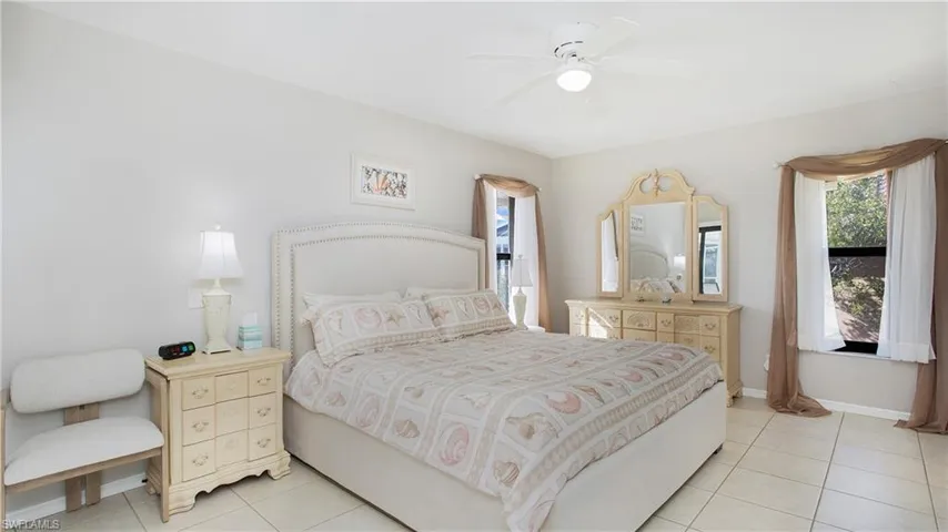 Tiled bedroom featuring ceiling fan