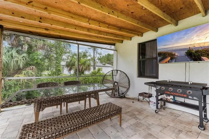 Sunroom featuring beamed ceiling and outdoor dining area