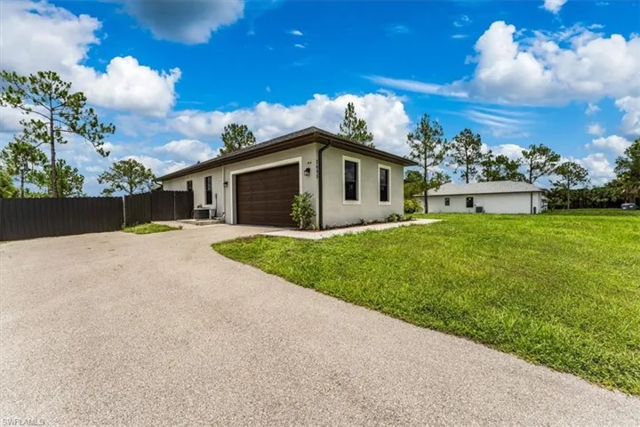Ranch-style home with a garage, stucco siding, and driveway
