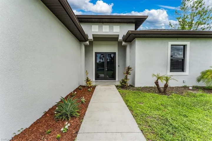 Entrance to property with stucco siding and french doors