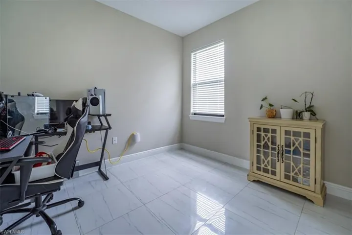 Office area with marble look tile flooring and baseboards