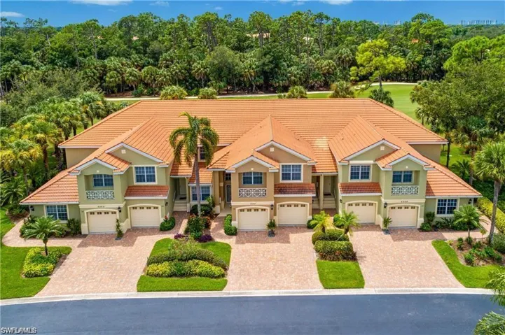 Aerial view of the Naples Florida condo community featuring attached garages, mature landscaping, and golf course surroundings.
