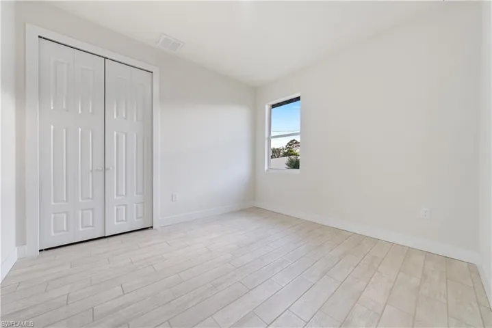 Unfurnished bedroom featuring wood tiled floors and a closet