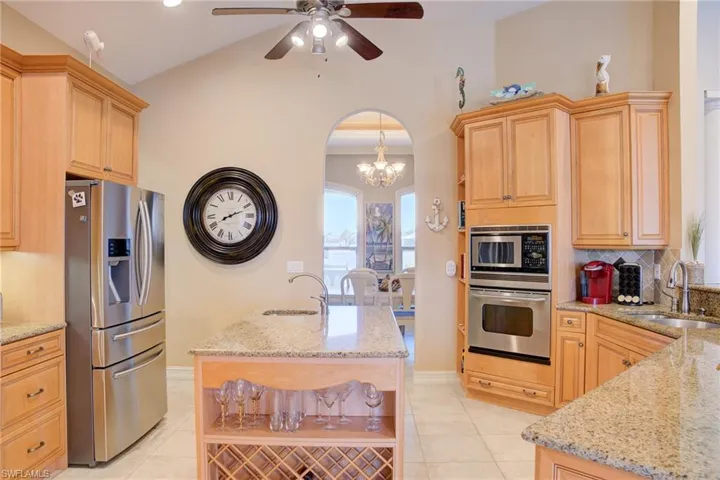 Kitchen with light tile patterned floors, stainless steel appliances, and a sink