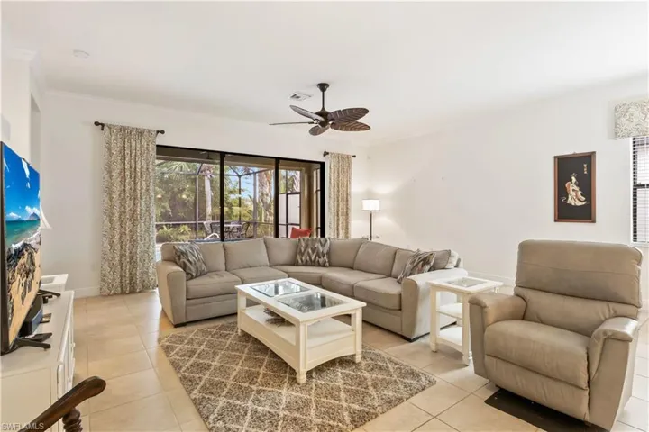 Living space that blends elegance and practicality, with a large sliding door view of the pool and preserve.