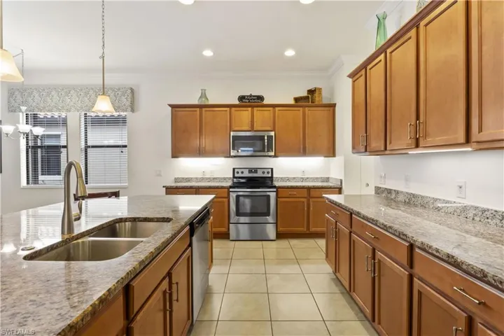 Chef-inspired kitchen featuring wood cabinetry, breakfast bar, and open sightlines to living spaces.