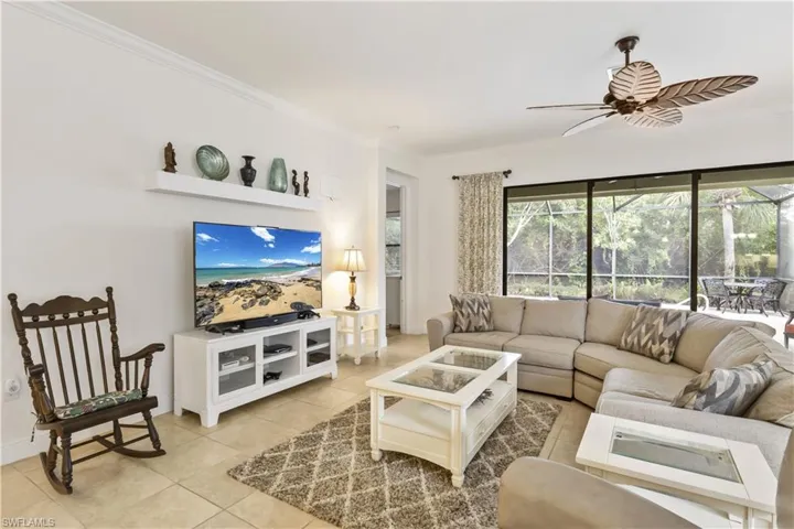 Elegant living area designed for relaxation and entertaining, with large windows overlooking the lanai and pool.