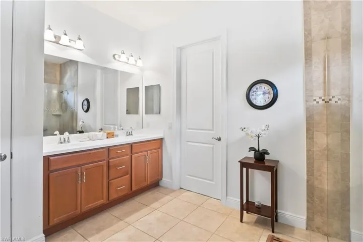 Primary suite bathroom with ample counter space, dual sinks, and a walk-in shower for convenience.