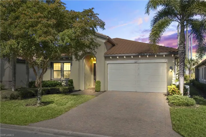 The home’s welcoming exterior and landscaped driveway come alive against a stunning sunset sky.