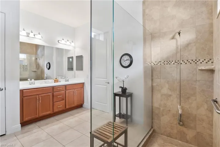 Primary suite bathroom with dual sinks, walk-in shower, and stylish tile accents.