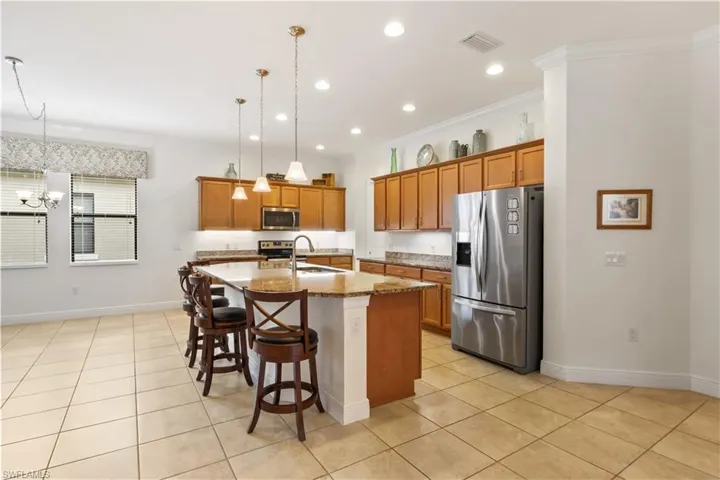 Gourmet kitchen featuring granite countertops, stainless steel appliances, and a large center island.