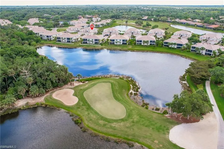 Aerial perspective of suburban area featuring a nearby body of water and a golf course