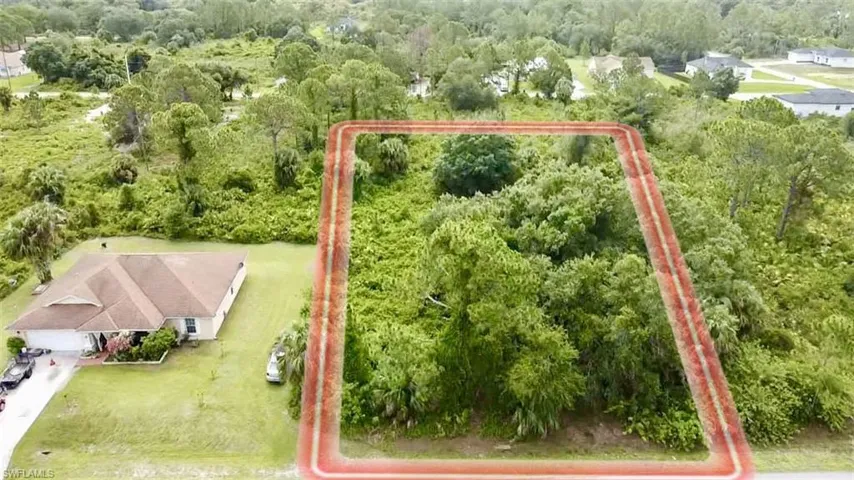 Aerial view of property and surrounding area featuring a heavily wooded area and property boundaries highlighted