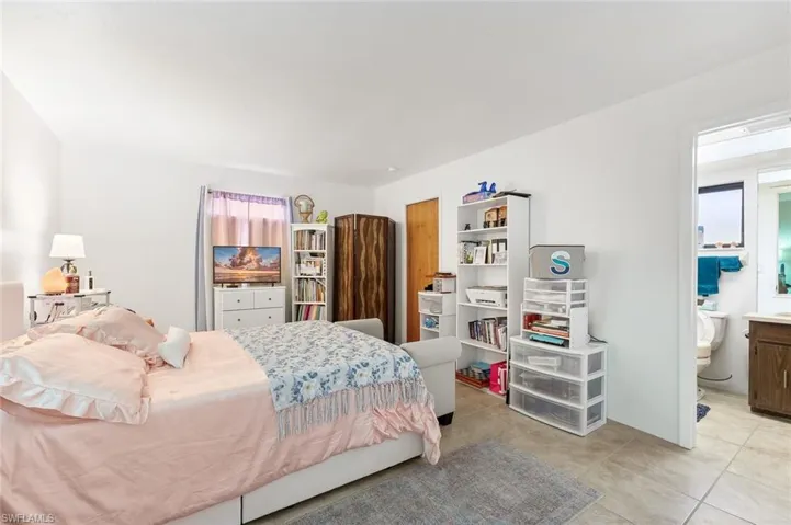Bedroom two with tile flooring and ensuite bath in unit #1.