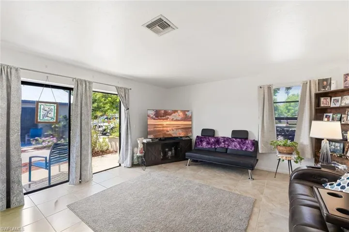 Living/Dining area with tile floors and slider to outside patio in unit #1.
