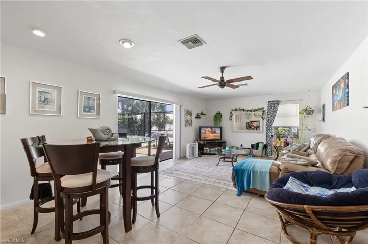 Living/Dining area with tile flooring, ceiling fan, and slider to outside pool and screened lanai area in unit #4.