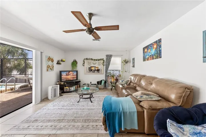 Living/Dining area with tile flooring, ceiling fan, and slider to outside pool and screened lanai area in unit #4.