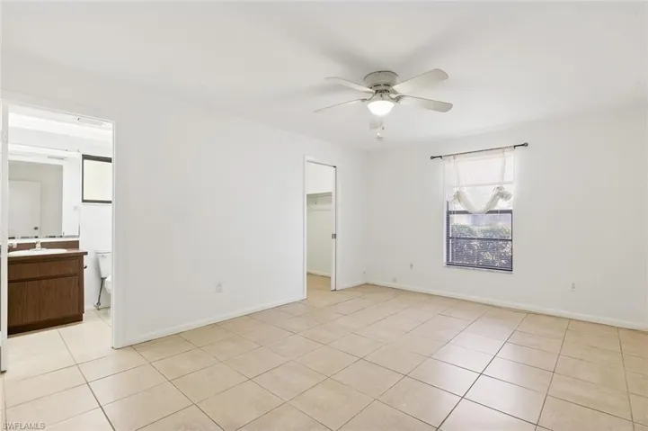 Bedroom one with tile flooring, walk-in closet, ensuite bath, and ceiling fan in unit #3.