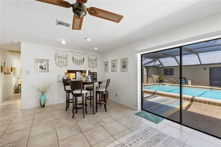 Living/Dining area with tile flooring, ceiling fan, and slider to outside pool and screened lanai area in unit #4.