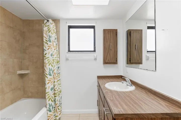Bathroom one with shower/tub combo and tile flooring in unit #1.