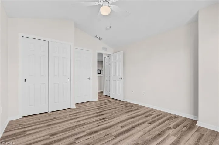 Unfurnished bedroom with a closet, light hardwood / wood-style floors, ceiling fan, and lofted ceiling