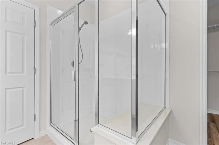 Bathroom featuring tile patterned flooring and a shower with shower door