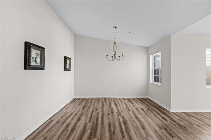 Unfurnished dining area with hardwood / wood-style floors and a chandelier
