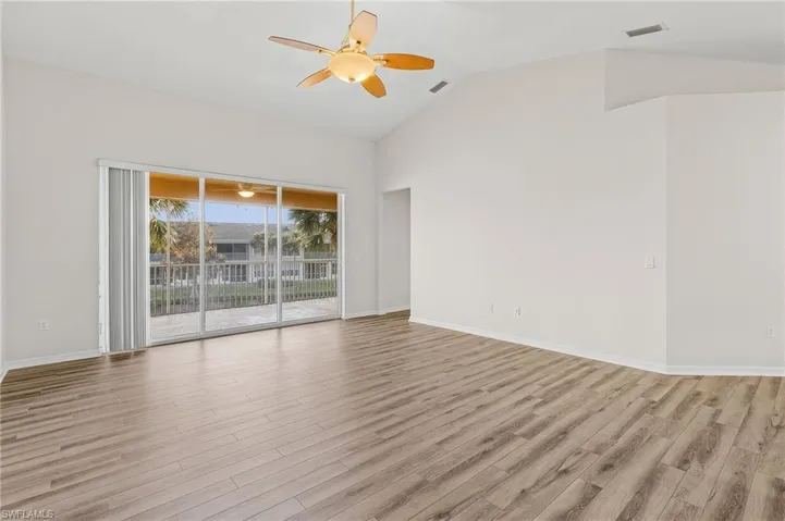 Empty room featuring ceiling fan, light hardwood / wood-style floors, and vaulted ceiling