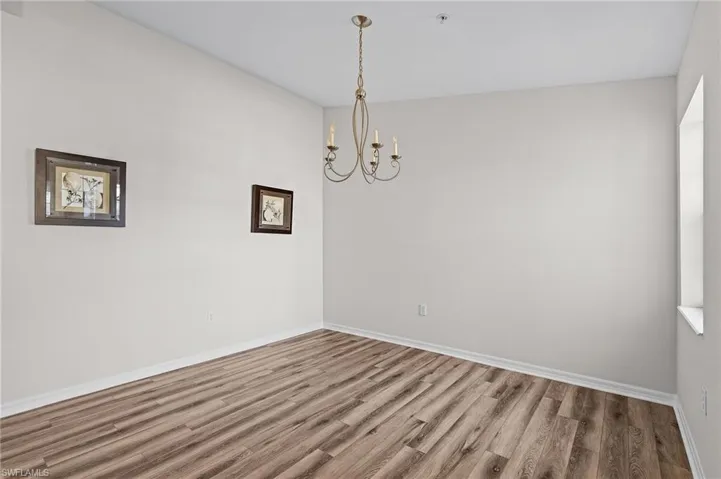 Unfurnished room featuring hardwood / wood-style flooring and an inviting chandelier