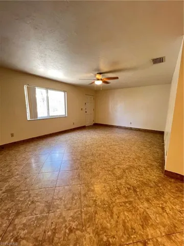 Living room featuring ceiling fan and a textured ceiling